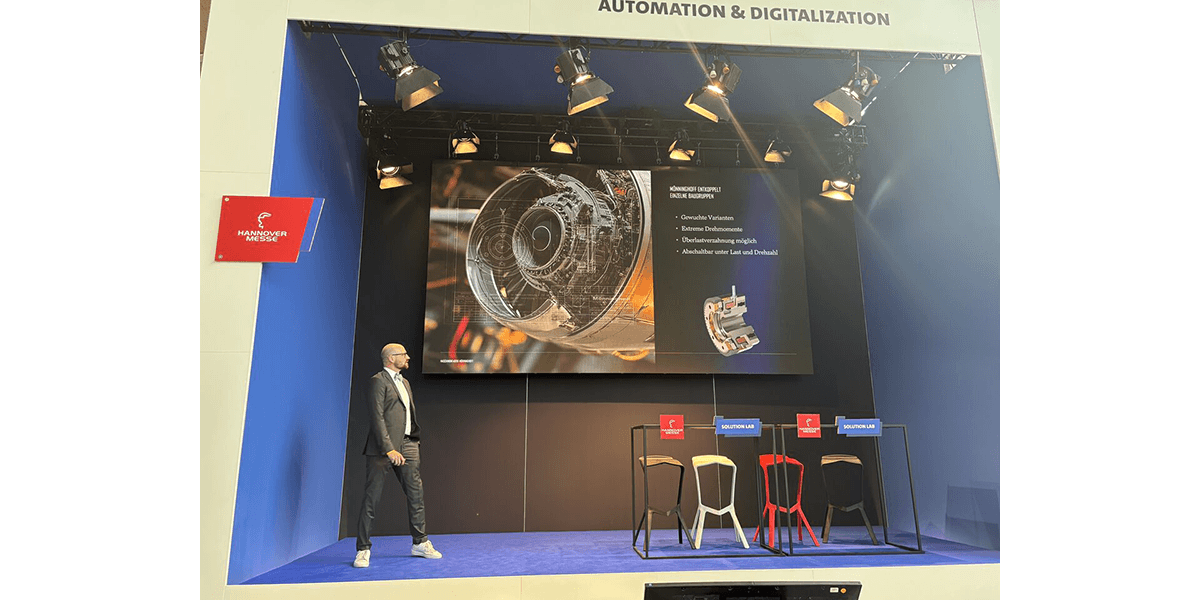 Bühnenpräsentation auf der Hannover Messe mit großem Bildschirm und 3D‑Visualisierung über die spannenden Einsatzfälle unserer Antriebstechnik!